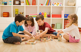 Four children playing with blocks on the floor