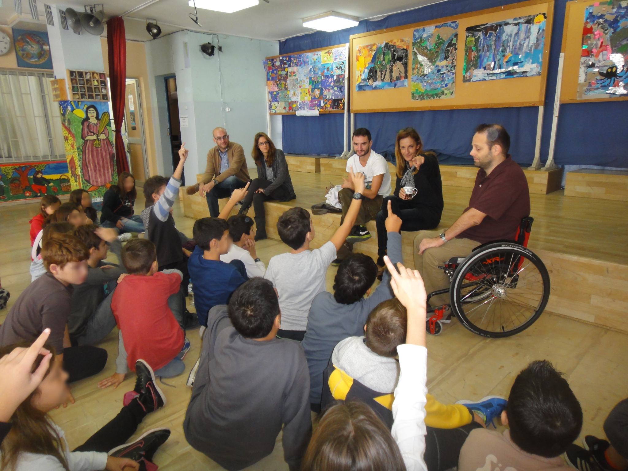 A man in a wheel chair giving a presentation to a group of students